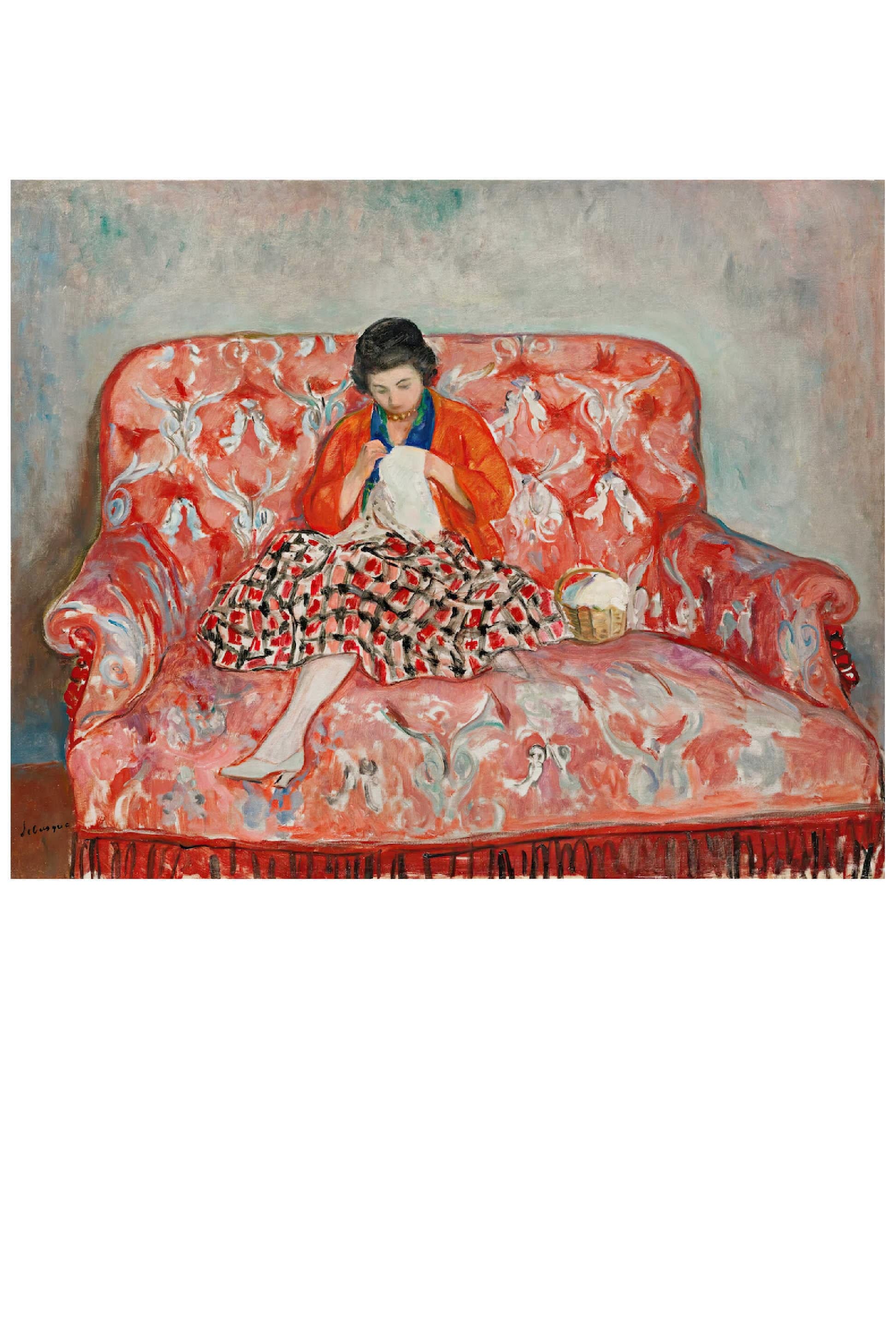 Woman knitting on a red patterned couch.