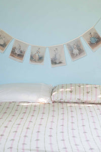 Ballerina garland above bed with Idony sheets
