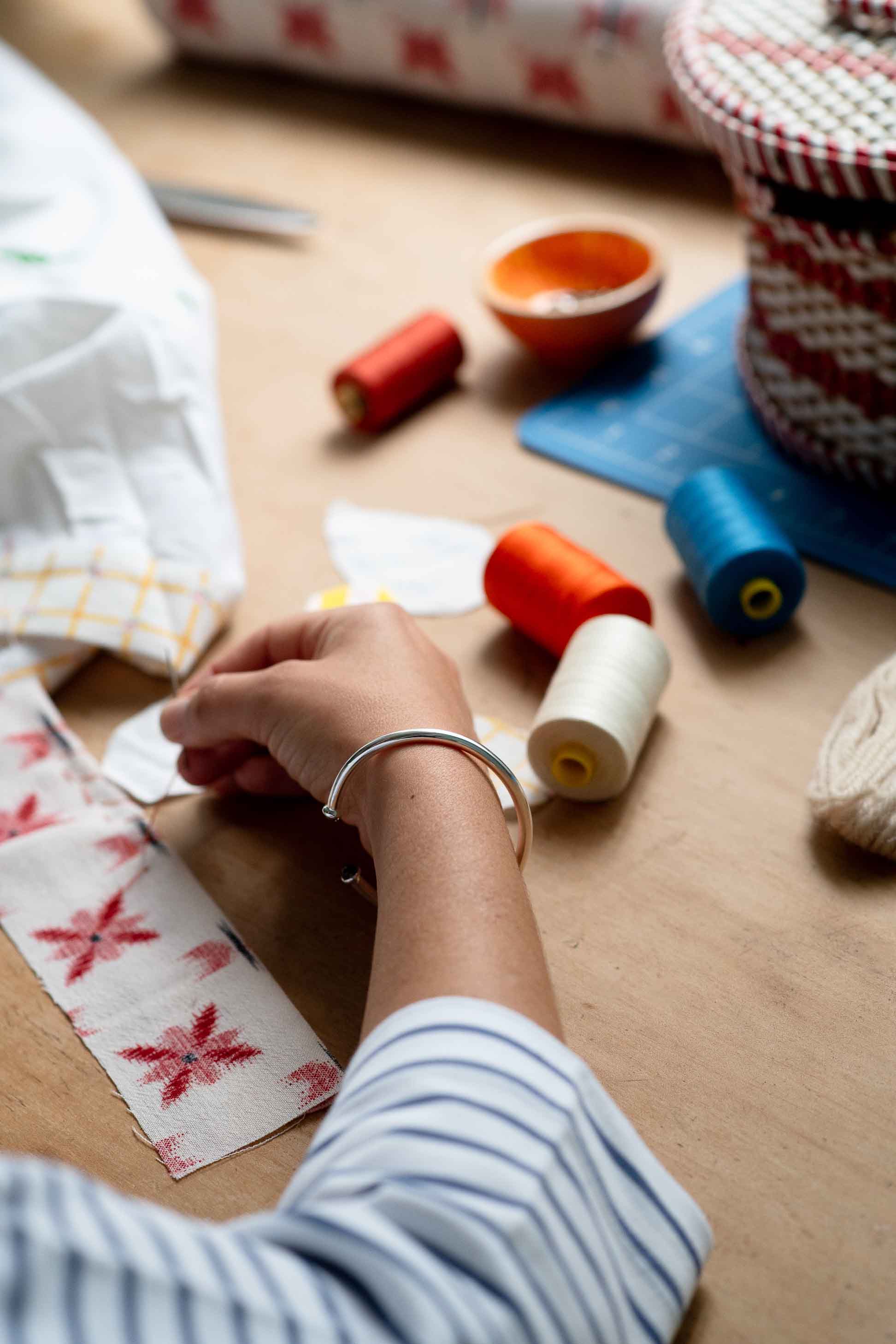 Bracelet on wrist with sewing supplies