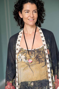 Woman wearing crystal locket, silver hoops & floral duster