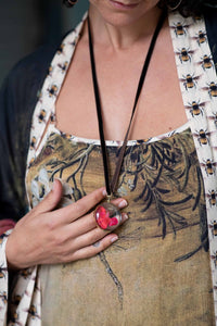 Woman wearing round crystal locket necklace