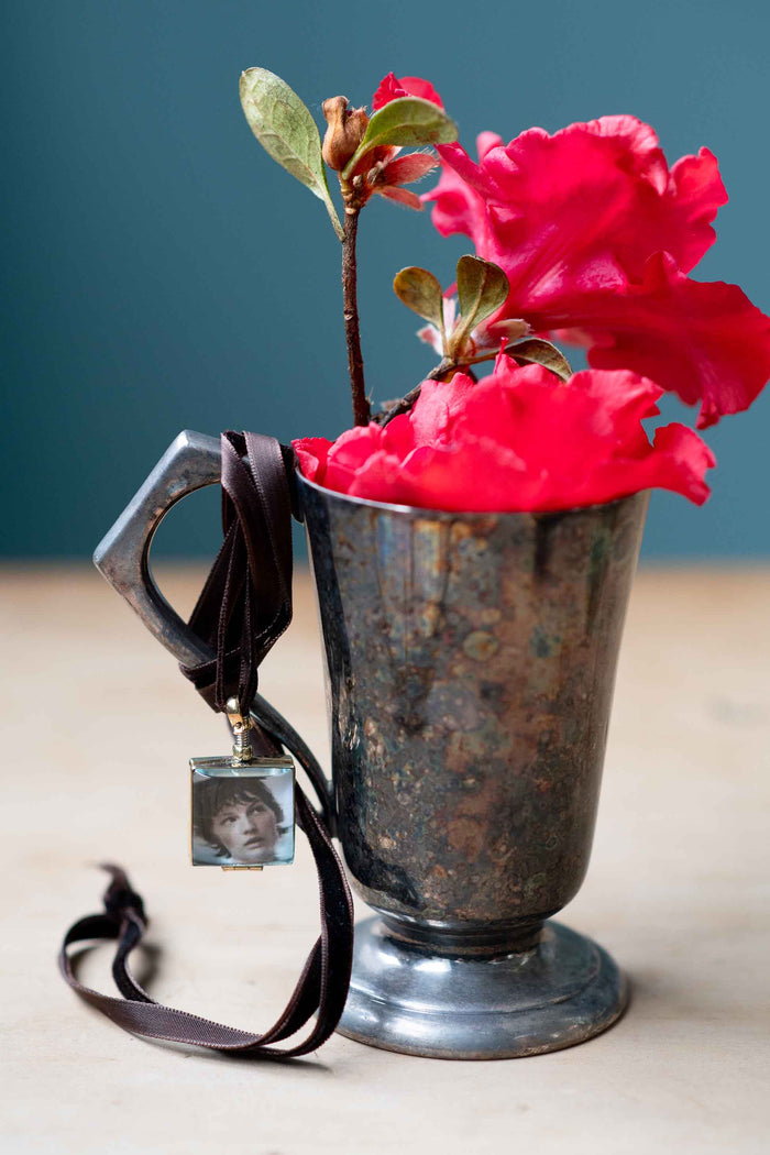 Crystal locket with portrait, red flowers in antique silver vase