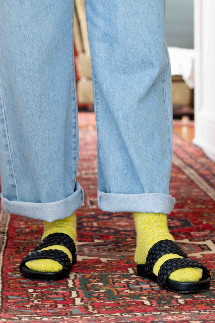 Lucy in yellow socks and jeans with black sandals