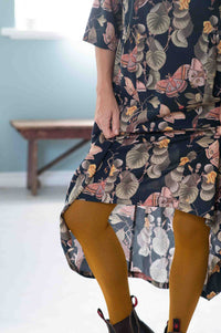 Woman in dress with ochre tights, Adele Merian Geo design.