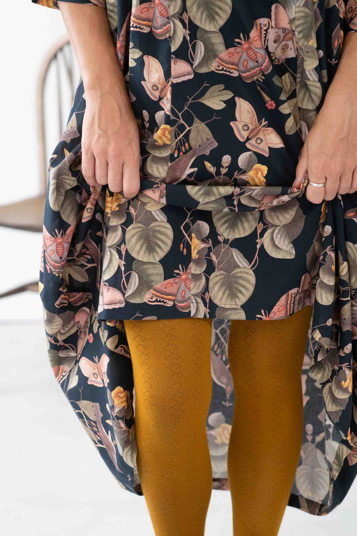 Woman wearing patterned dress and GeoOchre tights