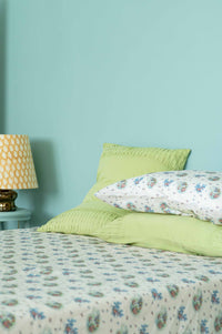 Green tea rosette sheets on bed with pillows