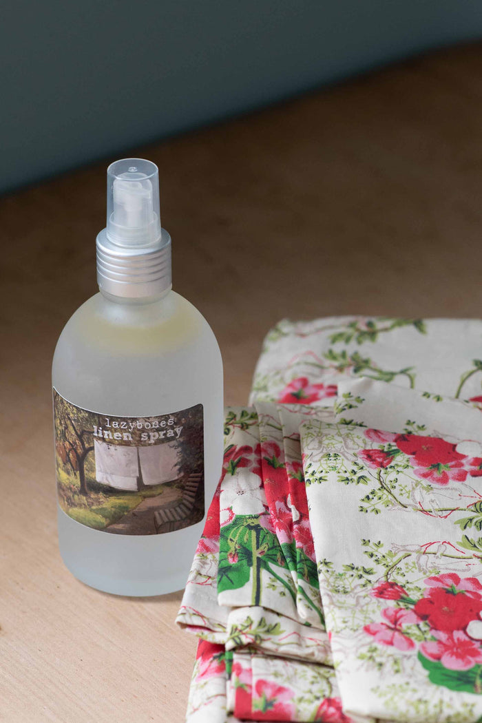 Lemongrass linen spray next to floral bedding