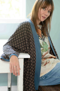 Woman in Lola cardigan and denim with insect print shirt.