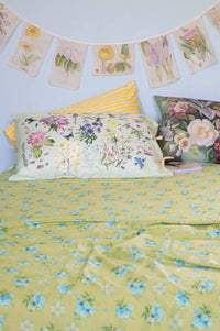Matilda Smith Garland painted floral sheets & cushions in a busy garden.