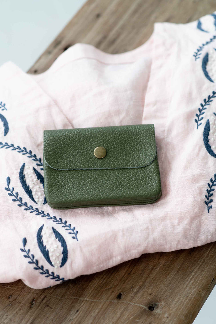 Moss green leather coin purse on pink cloth