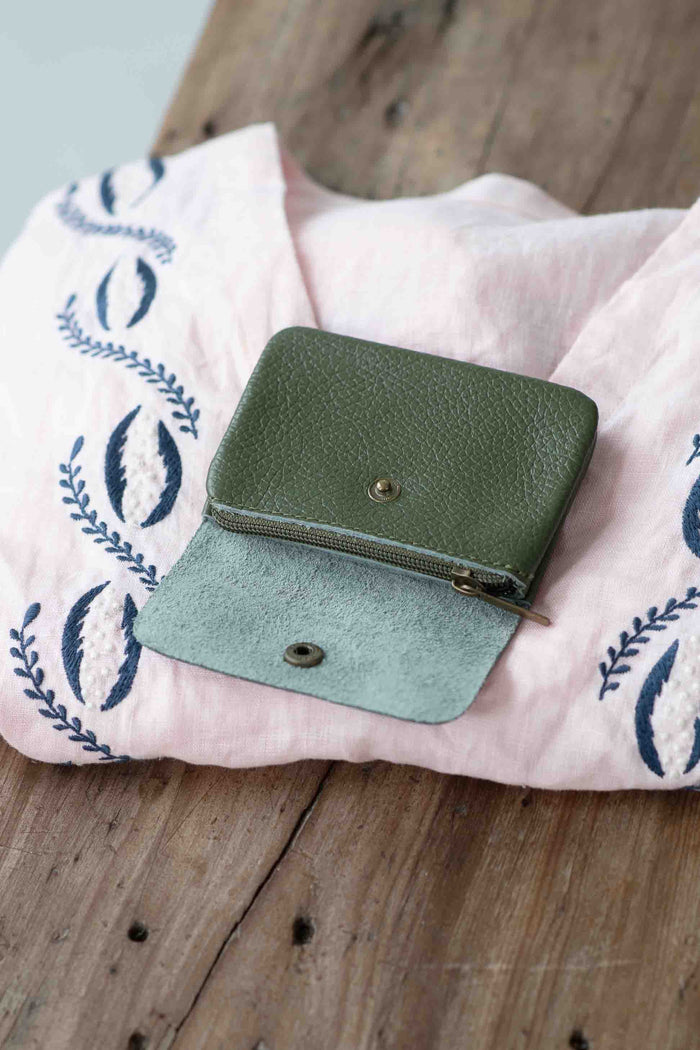 Moss green leather coin purse Simona on pink top