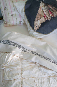 Moth on natural rosette bedding with La Belle sheets and cushion