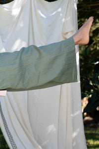 Ollie Mineral Green pants and foot against white drape.