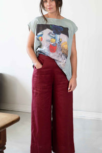 Woman in red pants and art print top, Peggy Still Life Ollie Red
