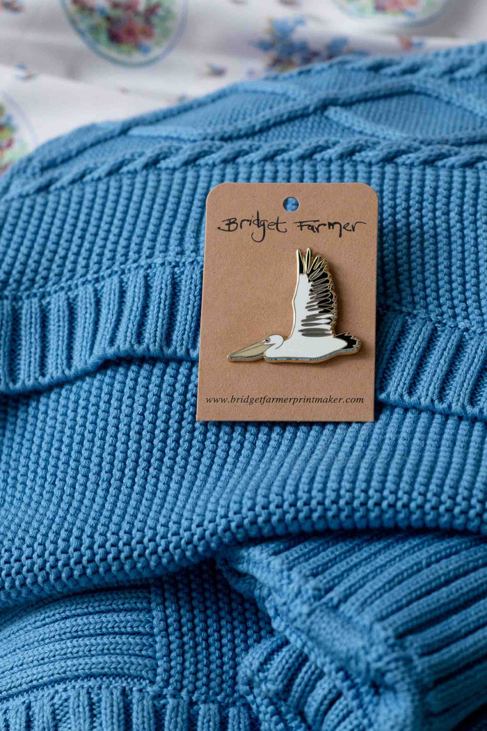 Pelican pin on blue knit blanket