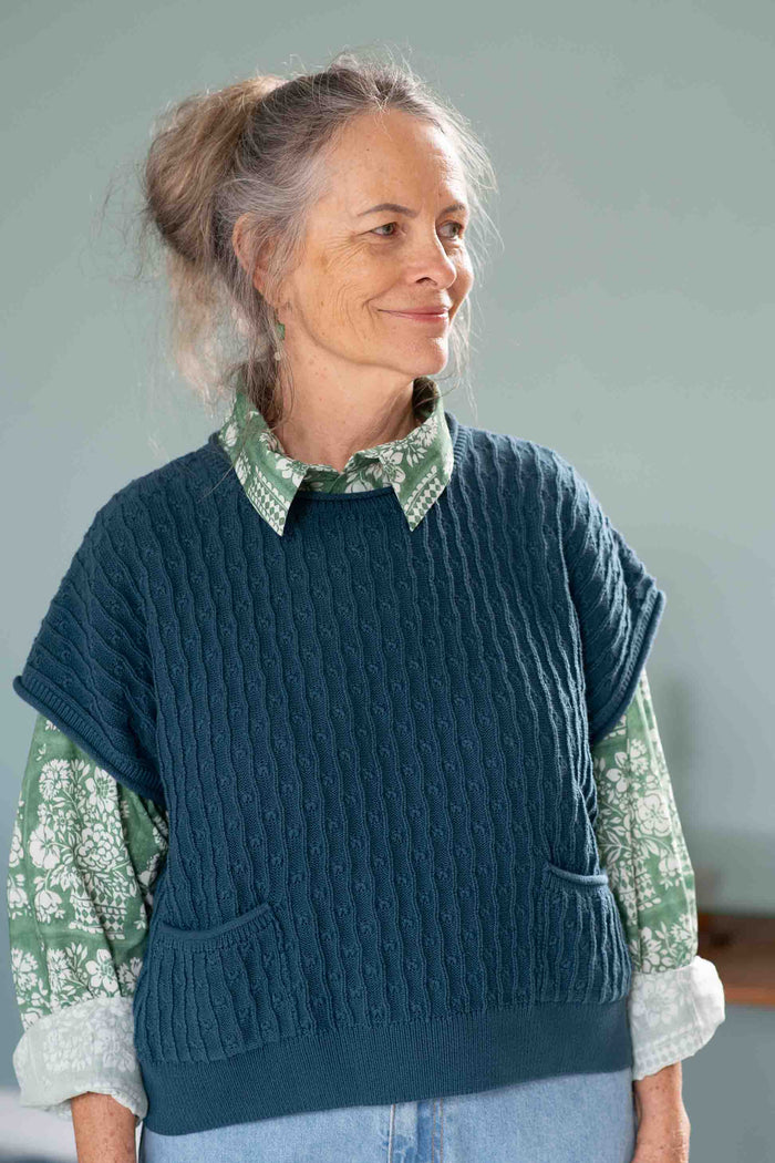 Woman in blue vest and floral shirt