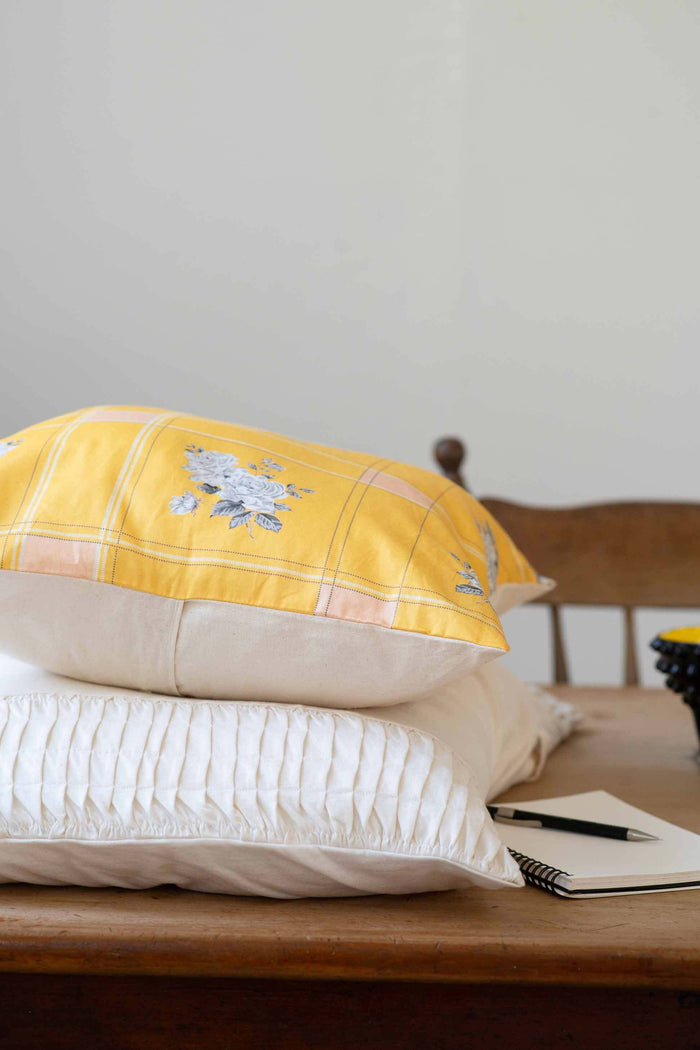 yellow rosette pillow and white pleated pillow