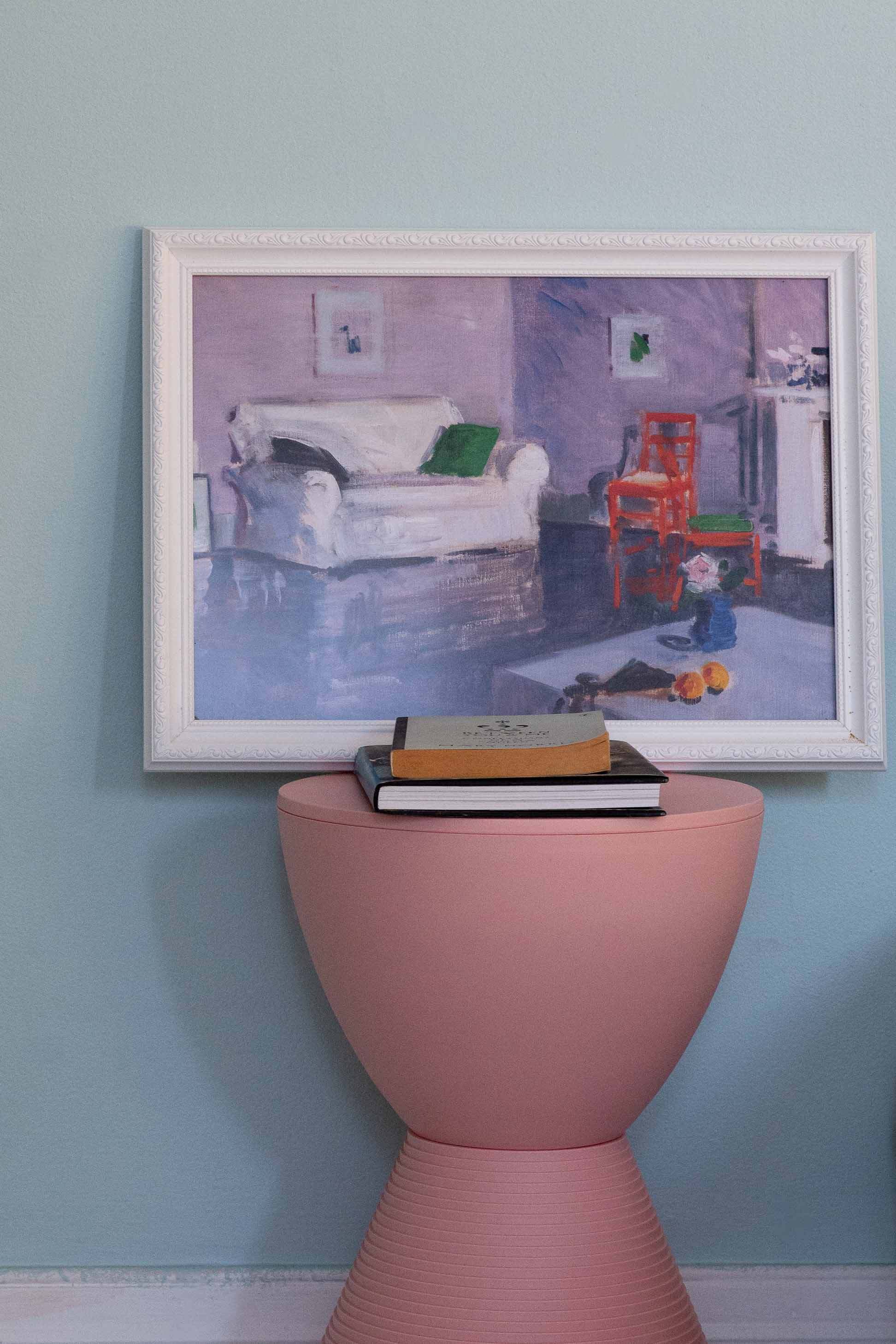 White sofa art print above pink accent table