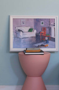 White sofa art print above pink accent table