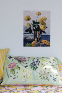 Still life with yellow roses in silver vase and floral pillow