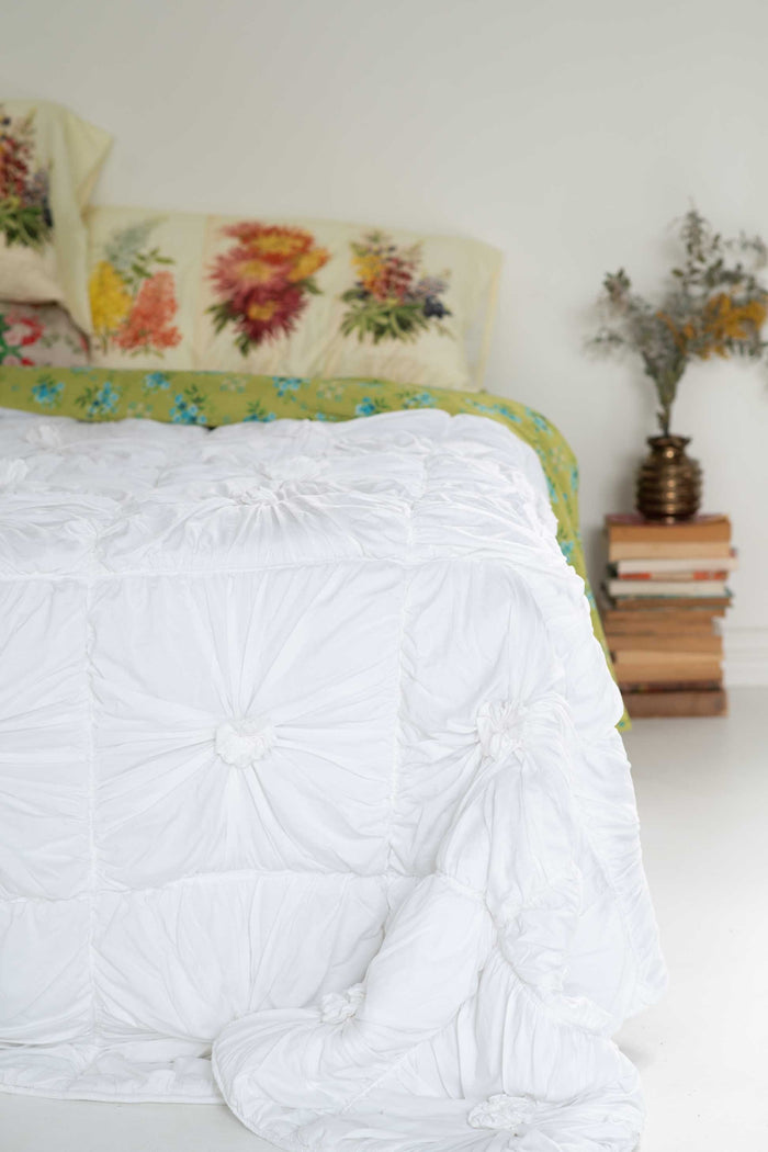 White rosette bedding with floral pillows