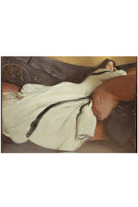 Woman in white dress reclining on a sofa.