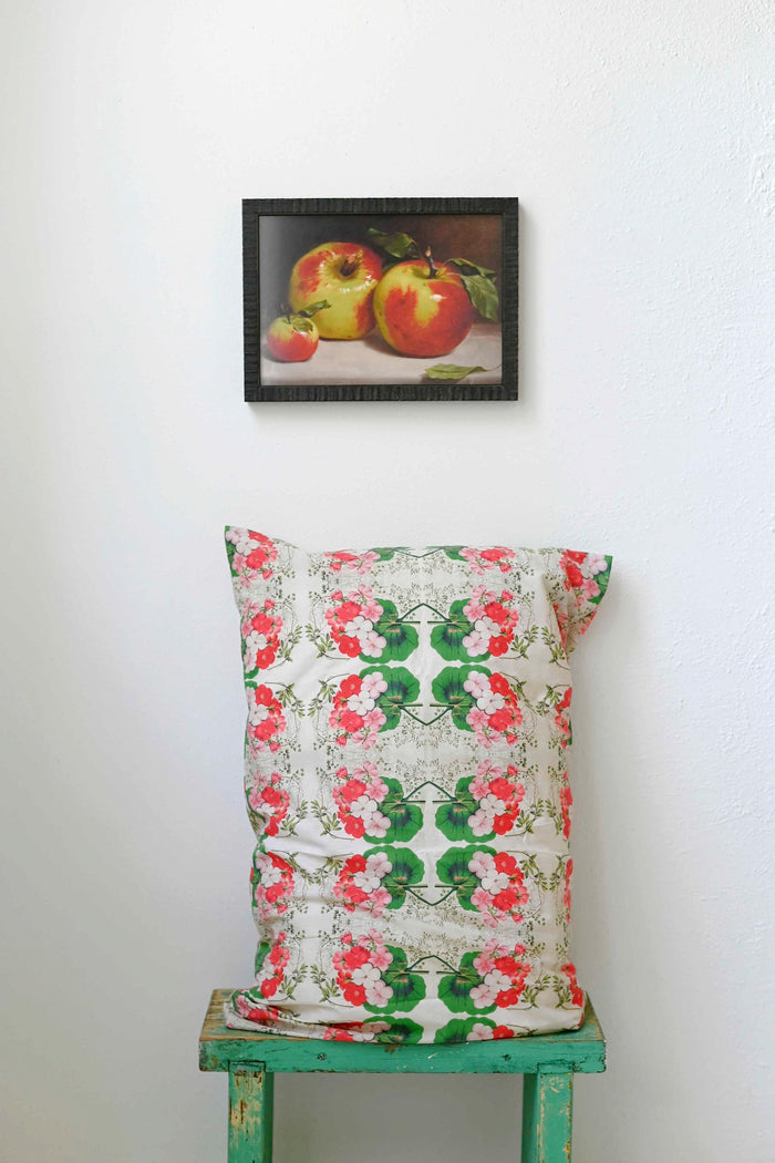 Art print of apples above pelargonium pillowcase.