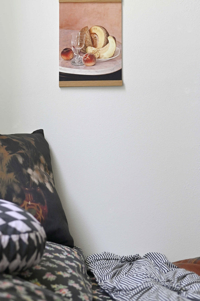 Art print of cantaloupe, peaches, bread, & glass on a plate.