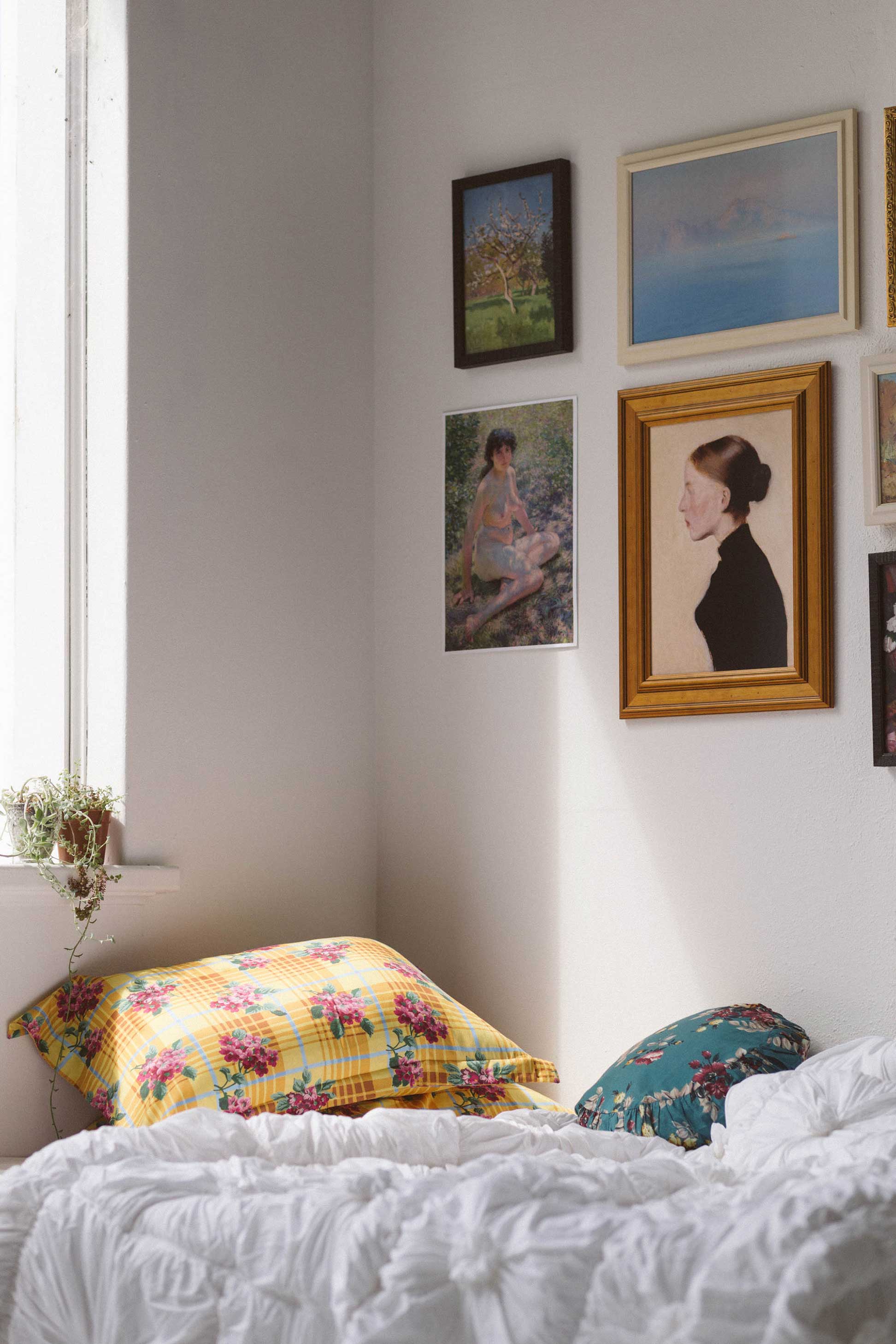 Picnic pillowcase set with Crisanta cushion and art prints in white bedroom.