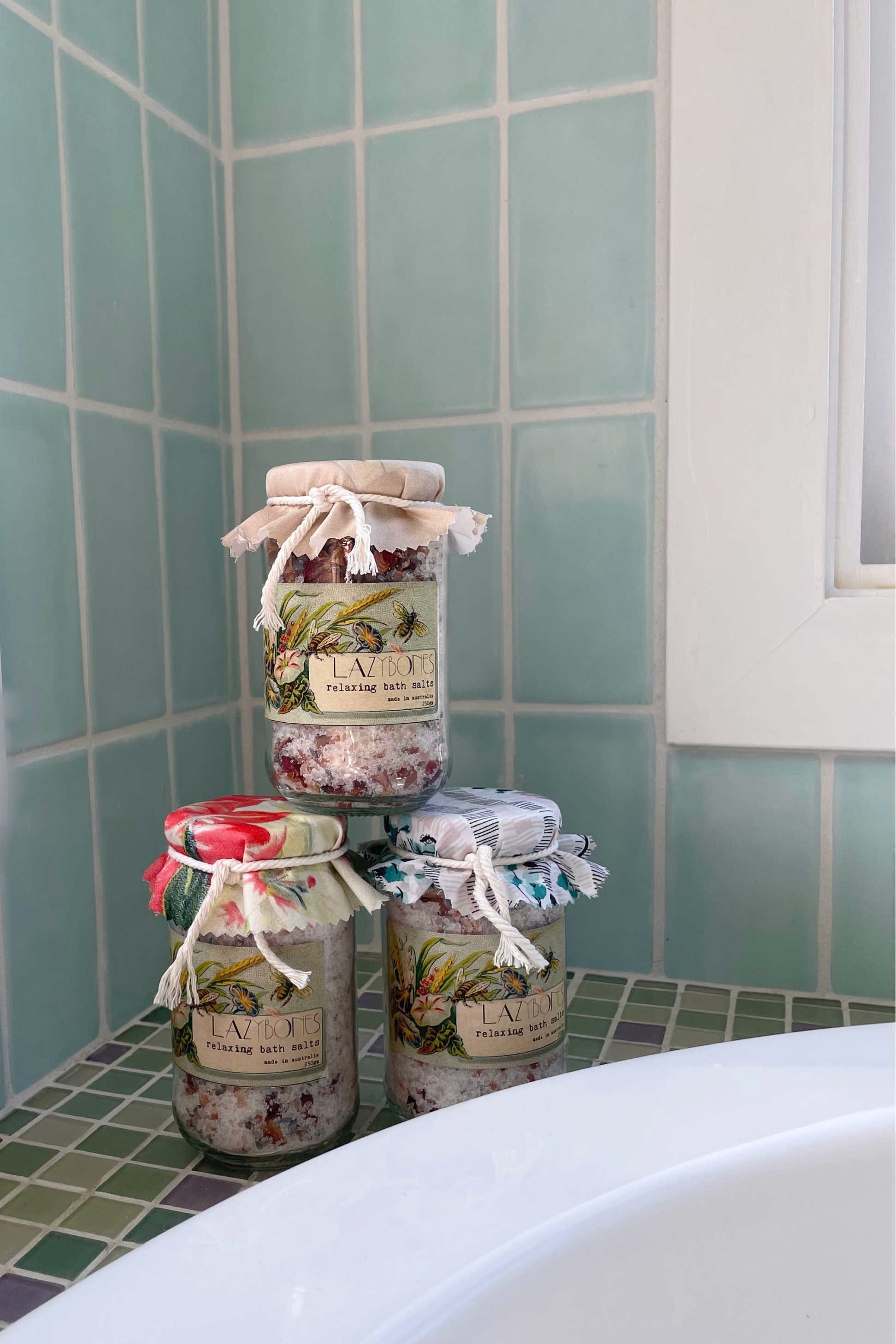 Bath salts jars stacked on a bathroom ledge