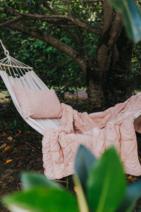 Pink quilt and pillow on hammock in garden