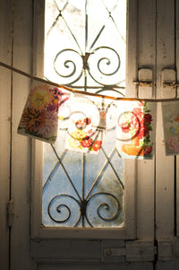 Vintage flower garland hanging in front of a window.