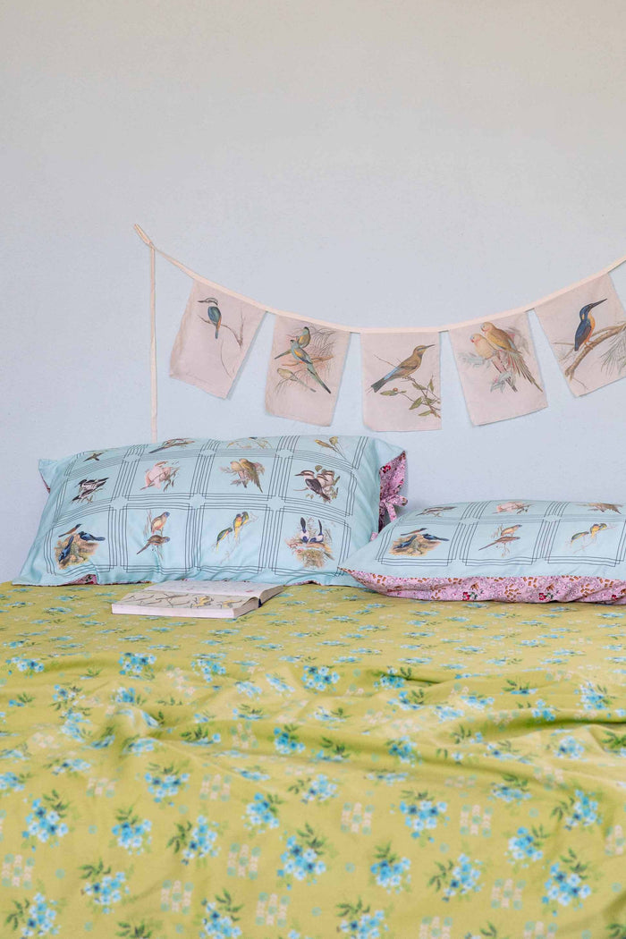 AustBirds pillowcase and garland with Avonlea sheets, birds on floral bedding.