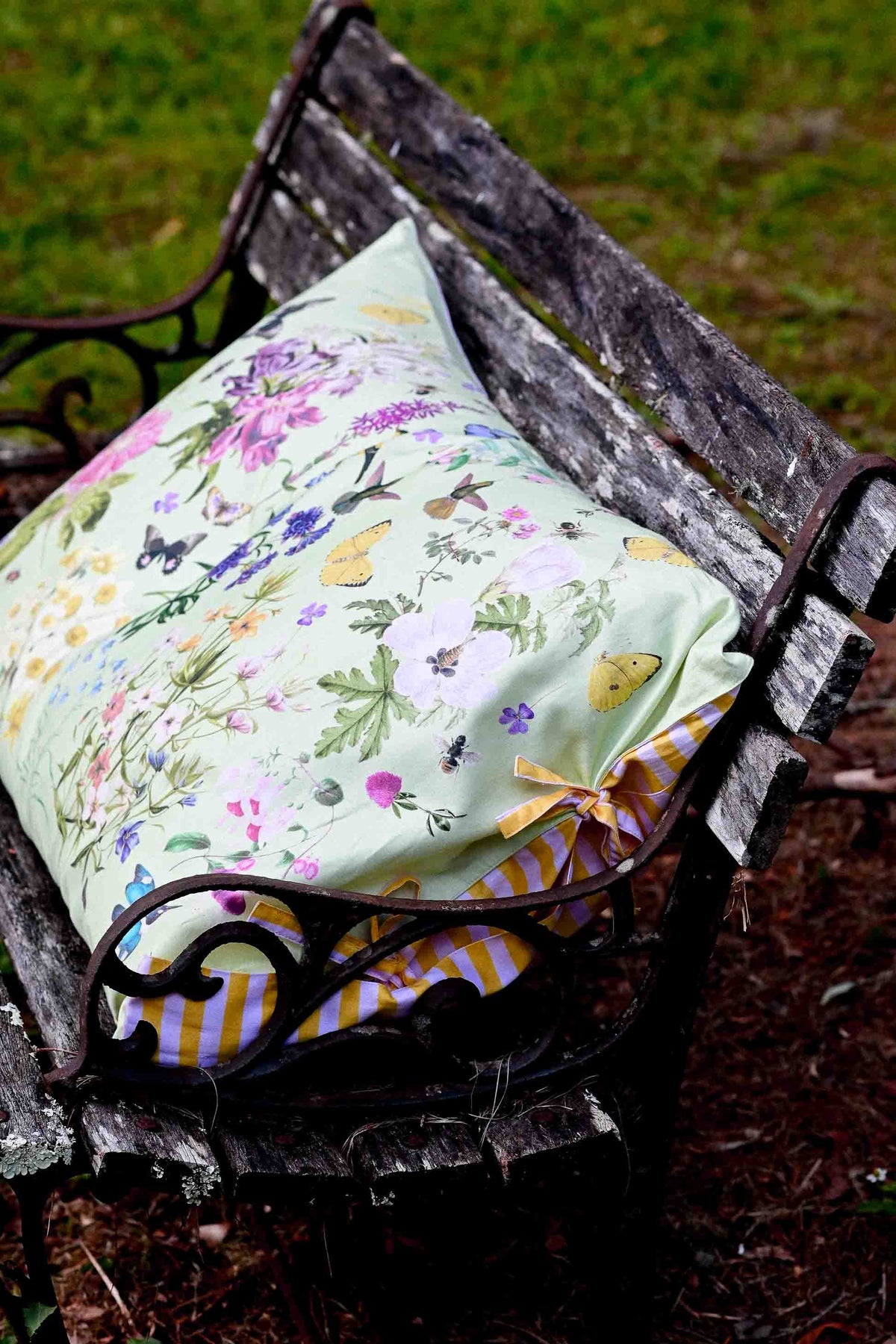 Busy Garden floral pillow on bench