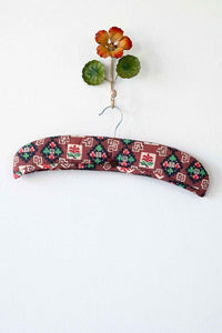 Clover-shaped padded hanger with floral design and wall decor