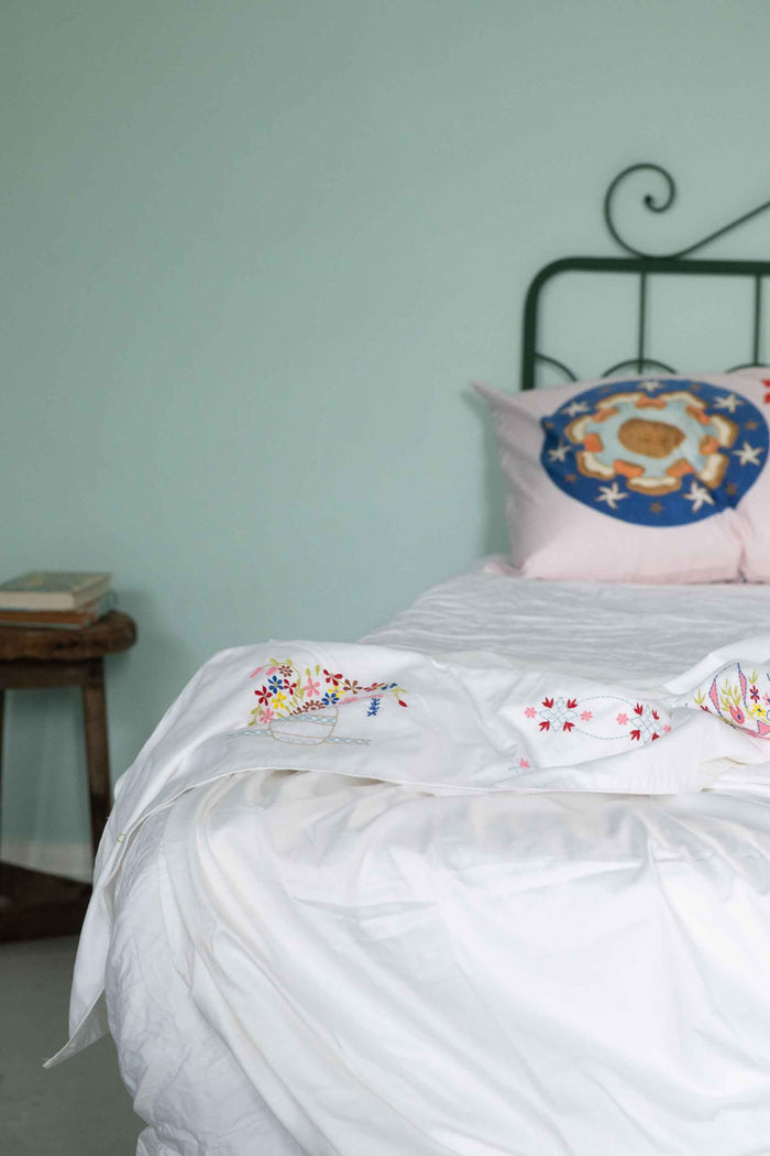 Bedroom with green headboard and floral pillow