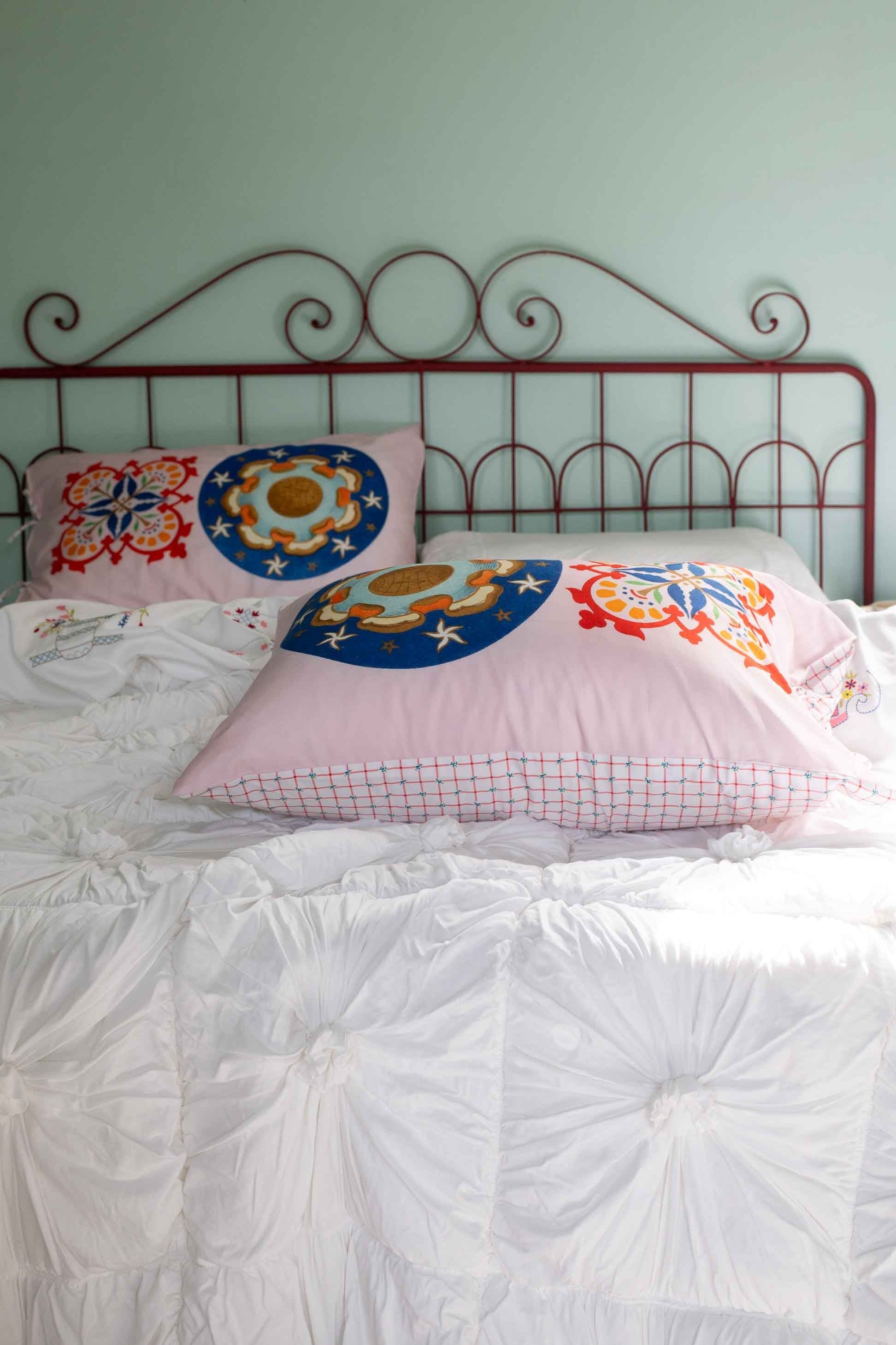 Bed with pink pillows and decorative headboard - DSC4974