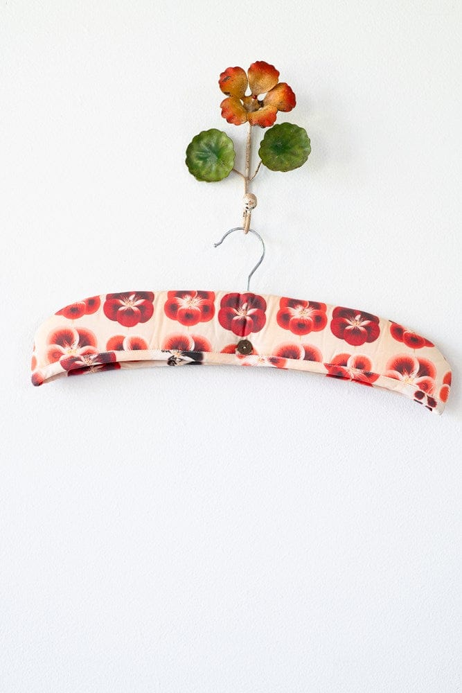 Floral padded hanger with decorative wall flower.