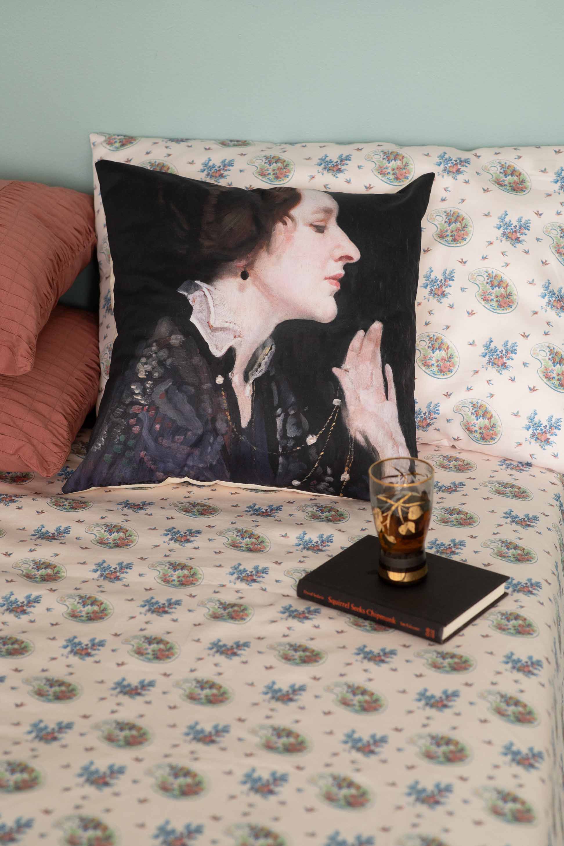Woman's portrait pillow, glass, book on bed - DSC9595
