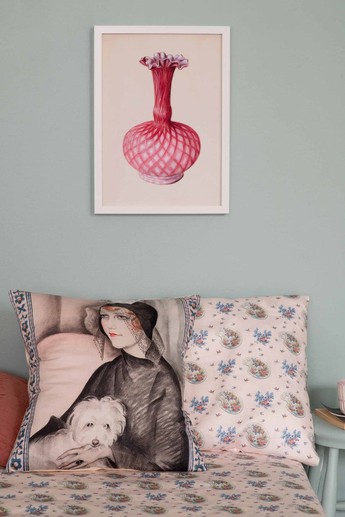 Woman with dog pillow and framed pink flower art
