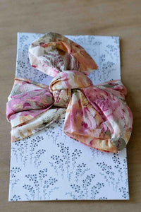 Floral bow tied on a patterned gift box