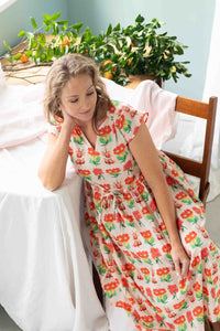 Heidi Florabelle in floral dress, seated near table with plants