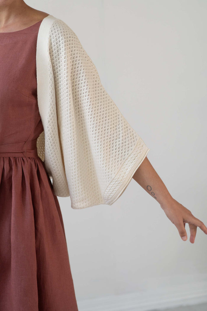 Woman in dress with off-white shrug