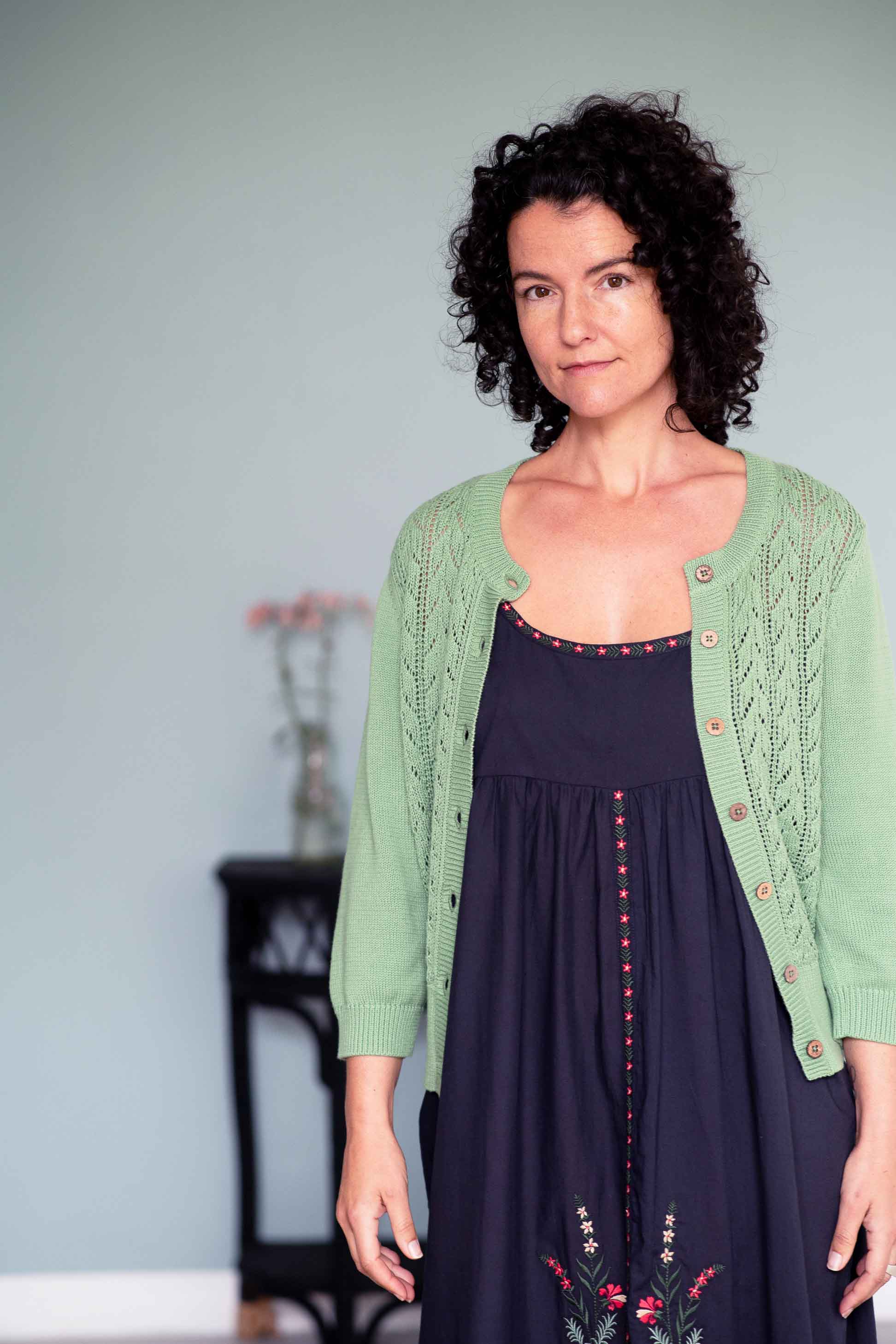 Juliet in charcoal dress with mineral green cardigan