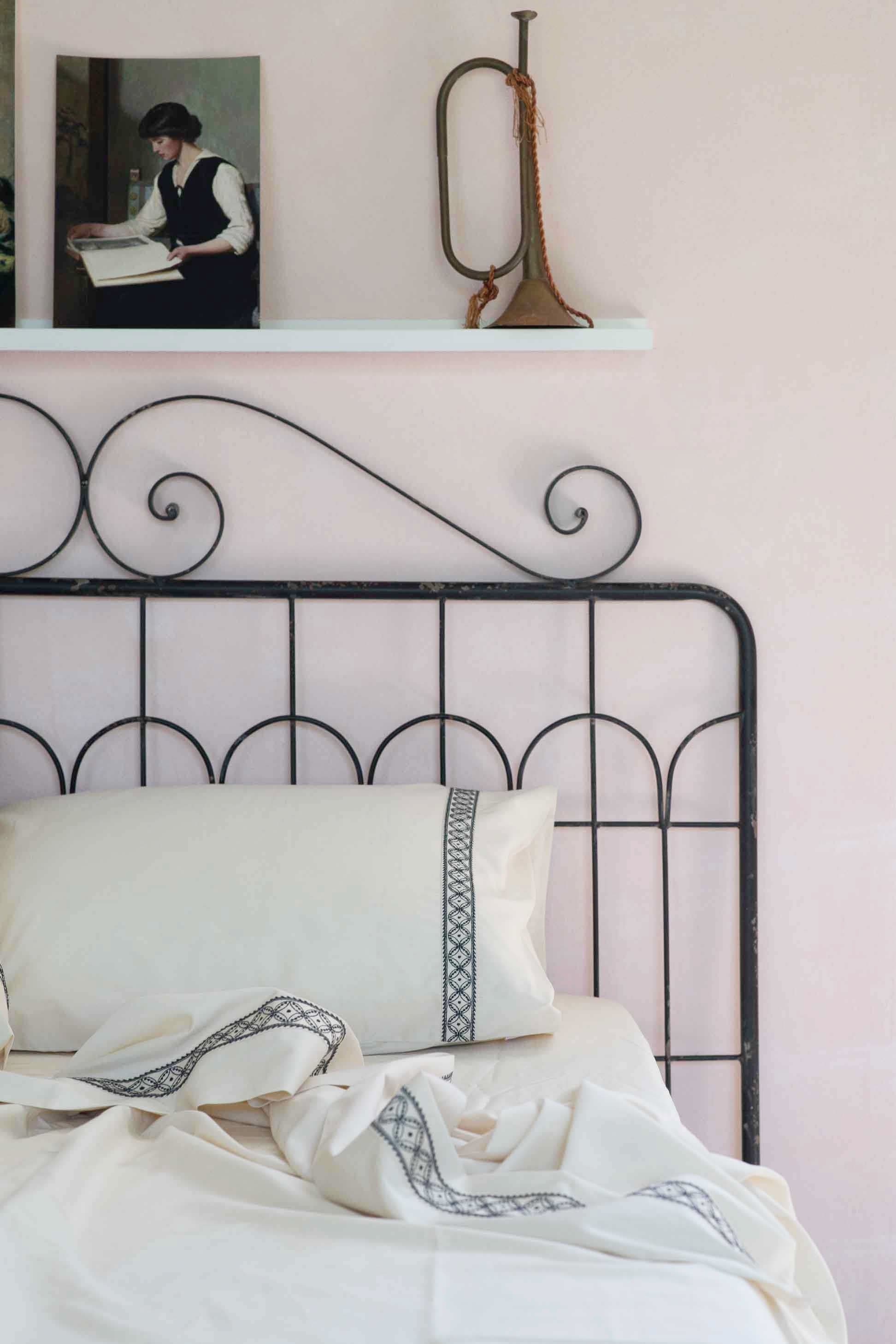 LaBelle Sheets bedding on wrought iron bed, with artwork and trumpet