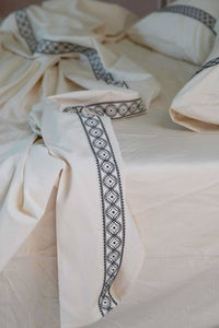 LaBelle Sheets with embroidered trim on bed
