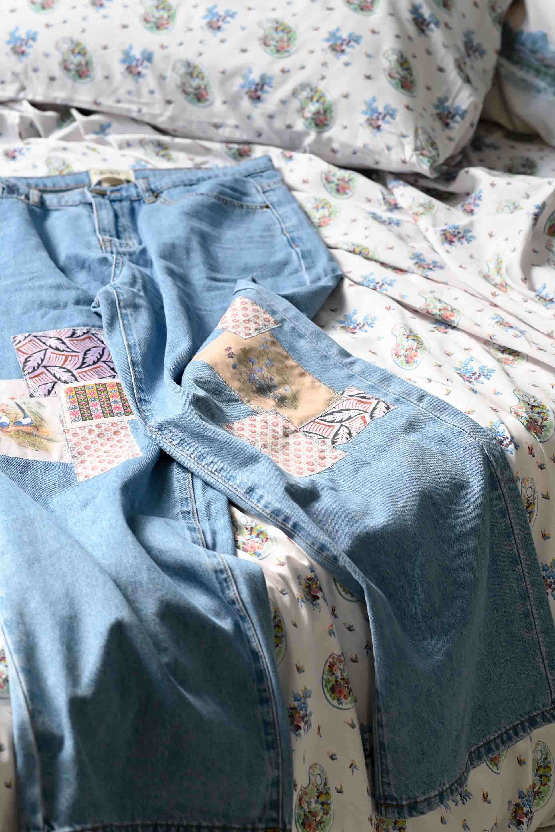 Lucy's patched jeans on floral bedding