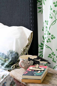 MagpieStandTranquilPillowcase scene with magpie, books, and patterned textiles.