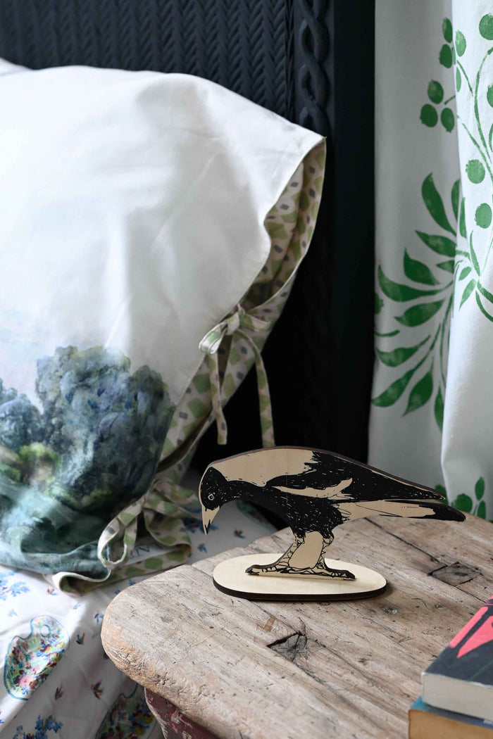 Wooden magpie figurine on bedside table
