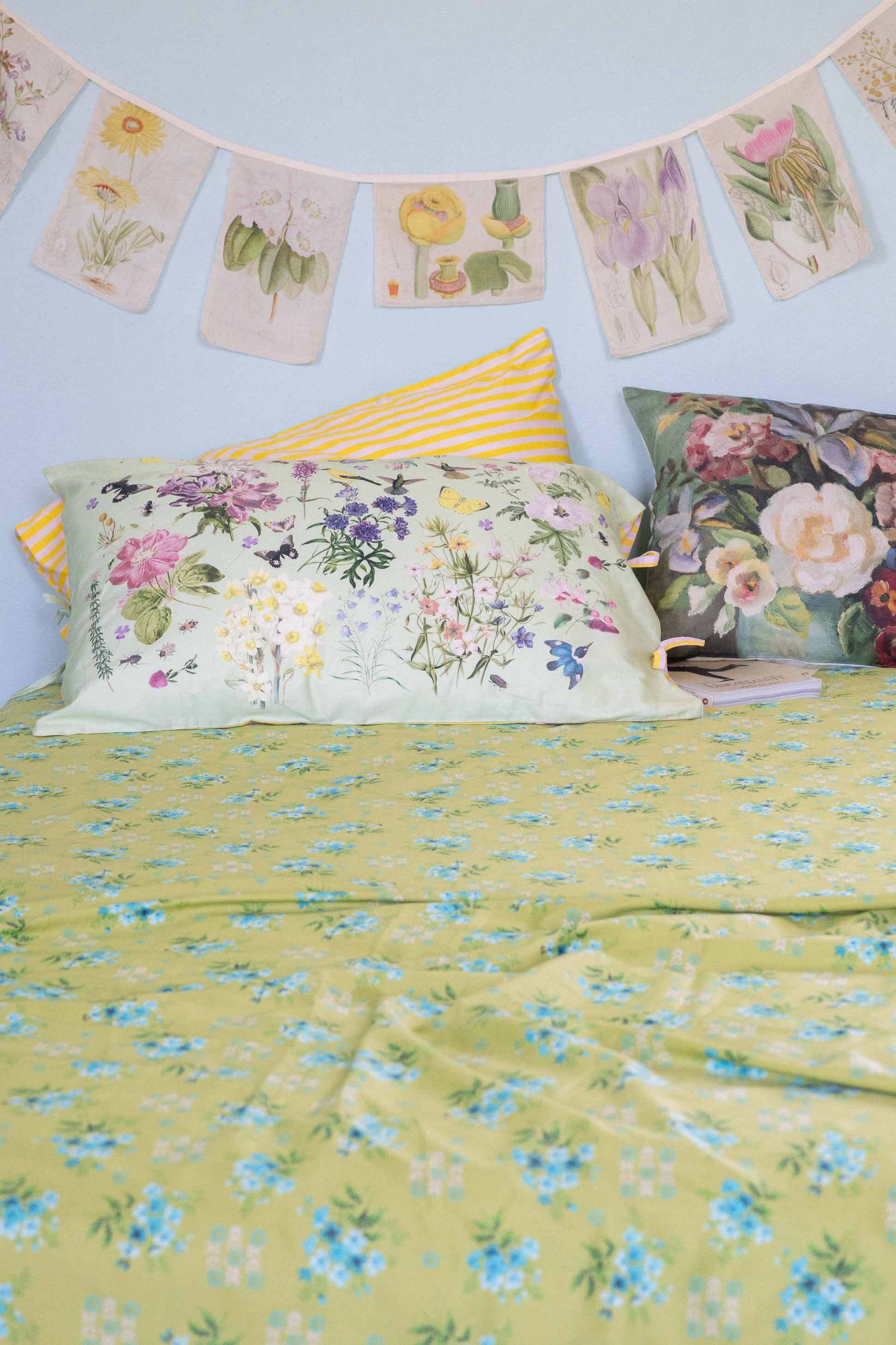 Matilda Smith Garland painted floral sheets & cushions in a busy garden.